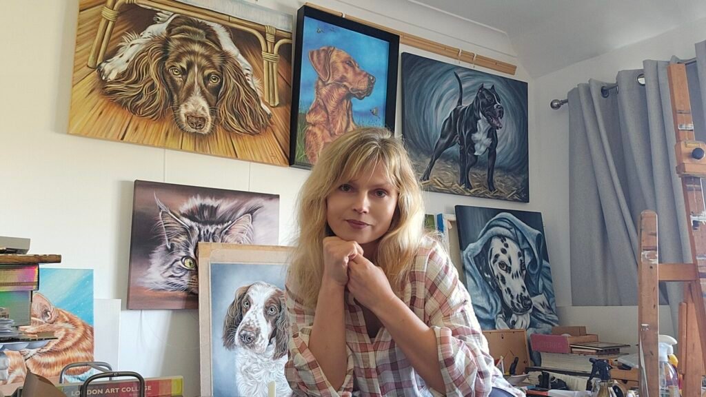 artist Irisha standing next to her original animal paintings